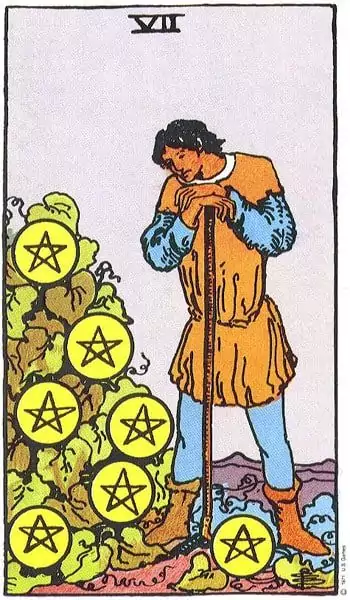 A man stands thoughtfully in front of a pile of seven pentacles, reflecting on his work and progress. The scene conveys themes of patience and assessment in the context of personal achievement.