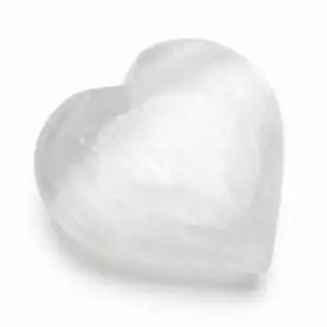 Smooth white selenite heart-shaped carved palm stone showing satin lustre and soft translucent glow on a neutral background