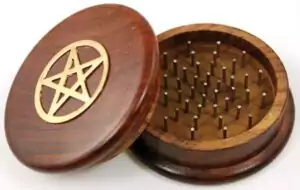Cast iron pentagram herb grinder with engraved five-pointed star design, heavy-duty ritual tool for grinding dried herbs and botanicals for spellwork and incense blending.