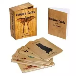 Conjure Cards deck with its wooden box and a guidebook, featuring illustrated cards in an Appalachian folk art style.