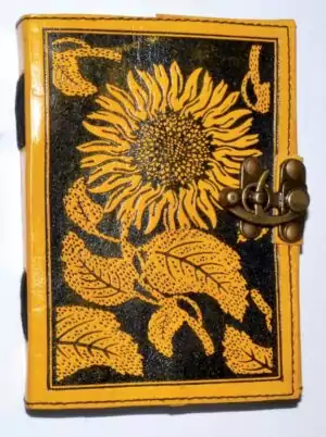 Leather-bound blank journal with embossed sunflower design on the cover and a decorative latch closure, suitable for use as a grimoire or spell journal.