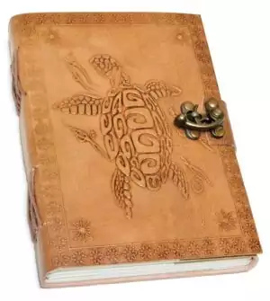 5x7 inch turtle embossed leather journal with cord closure showing detailed raised turtle design on cover and aged parchment-style pages inside — a handmade nature journal.