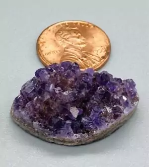 A one-inch Uruguayan amethyst marquise druse cabochon with eye-shaped outline and sparkling deep purple druzy crystal surface and flat back.