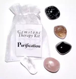 A purification gemstone therapy kit showing an assortment of cleansing crystals including white and black stones arranged for a crystal healing and ritual cleansing practice.