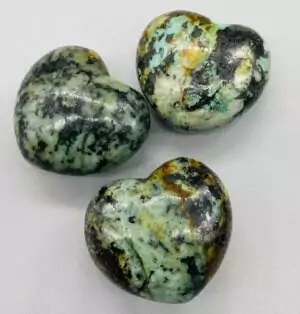 1 and 3/4 inch carved African turquoise heart crystal in blue-green and black tones for growth and gifting