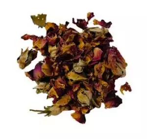 Dried red rose buds and petals Rosa gallica in a scattered pile showing deep red and pink flower pieces for love ritual use
