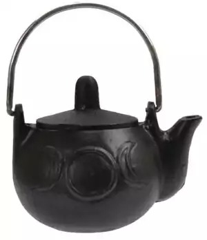 Small black cast iron cauldron with rounded body and handle featuring embossed crescent moon designs, three-legged base shown on white background