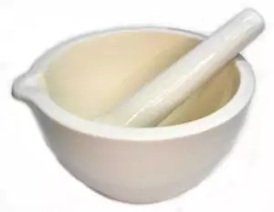 A 7-inch white ceramic mortar and pestle set, showing a round bowl with pour spout and cylindrical grinding pestle, for herb grinding and ritual apothecary use.