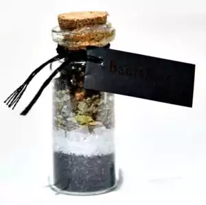 Banishing pocket spell bottle — miniature ritual intention jar filled with protective herbs and crystals for banishing negative energy and harmful influences.