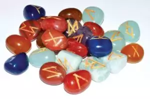 Seven chakra gemstone rune set with Elder Futhark runes carved on rainbow colored crystal tiles for Norse divination and chakra work