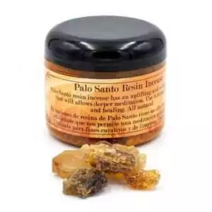 2oz jar of palo santo granular resin incense with loose resin pieces scattered beside it, for use on charcoal discs in ritual burning.