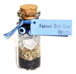 Small glass vial spellbottle filled with crystals and herbs sealed with cork and blue Against Evil Eye label tag, pocket protection charm