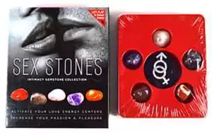 Sex Stones gemstone kit displayed in a red tray with assorted crystals in varying shapes and colors, accompanied by a box with intimate-themed packaging art.