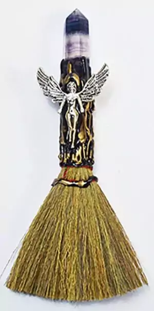 7.5-inch besom broom wand with a purple fluorite crystal point tip, silver winged angel figure, and natural fiber brush end for ritual cleansing altar use.