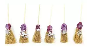 Five 6-inch mini altar brooms with different colorful decorative tops arranged in a line, showing a variety of embellishments for Wiccan altar use.