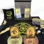 Rider-Waite black and gold foil tarot cards displayed on black cloth with crystals, a feather, and a decorative box showing mystical tarot imagery.
