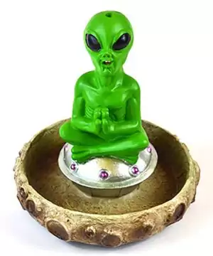5 3/4-inch cold cast resin alien figurine sitting cross-legged on a silver flying saucer, for cone incense burning on cosmic-themed altars.