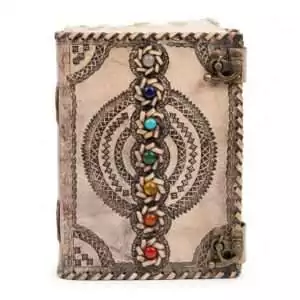 Decorative leather-bound journal with chakra gemstone inlays and intricate tooled patterns on the cover — dual metal clasp closure.