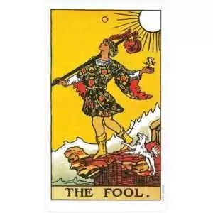 Rider-Waite Tarot Fool card — colorful figure in motley stands on a rocky ledge holding a small bundle, from the Restored Edition deck.