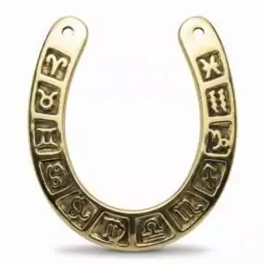 Golden cast metal horseshoe with all 12 zodiac signs engraved around the curve — intricate decorative talisman for luck and astrology display.