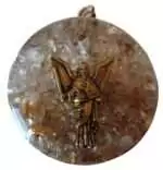 One and three quarter inch Uriel orgone pendant with clear quartz and citrine stones set in layered resin and metal matrix displayed on a white background