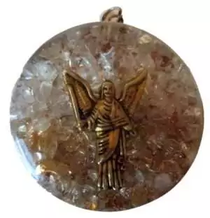 One and three quarter inch Uriel orgone pendant with clear quartz and citrine stones set in layered resin and metal matrix displayed on a white background