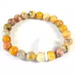Eight millimeter crazy lace agate beaded stretch bracelet showing cream, red, and golden swirling banded stone pattern on a white background