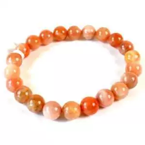 Eight millimeter peach moonstone beaded stretch bracelet with soft peachy feldspar beads showing subtle adularescent sheen on a white background