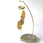 Freestanding table chime with natural banded agate slice rods hanging over a natural agate base, showing translucent stone coloring on plain background