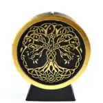 A black wax Tree of Life figure candle showing a detailed tree silhouette with spreading branches and roots molded into the front of the candle on a plain background
