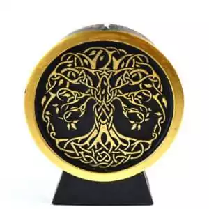 A black wax Tree of Life figure candle showing a detailed tree silhouette with spreading branches and roots molded into the front of the candle on a plain background
