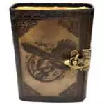 Dark brown faux leather journal with embossed raven perched on a skull design on the cover, metal latch closure, aged parchment-style interior pages