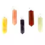 Set of twelve mixed crystal pencil point pendants in assorted stone varieties including amethyst, rose quartz, and citrine displayed together on a white background