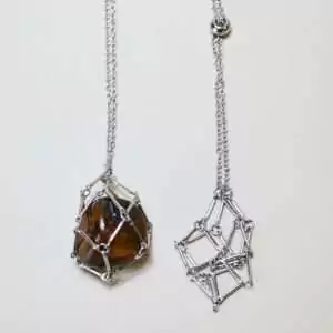 Set of four 24-inch stainless steel chain necklaces each with an open wire stone cage pendant displayed on a white background