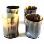Set of four small bone-carved shot glasses for ritual libation offerings, arranged together on a plain surface