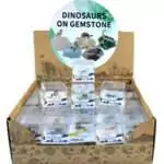 Set of 60 small colorful dinosaur figurines each mounted on a natural mineral or gemstone base, displayed together showing variety of stone colors and dinosaur poses