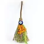 Eleven-inch ritual herb besom broom with bundled dried herbs and blue evil eye nazar charm woven into the handle, shown against plain background