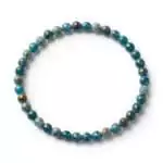 4mm faceted apatite beaded stretch bracelet with sparkling teal-blue faceted beads on elastic cord, shown on plain surface