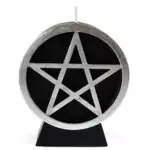 A black wax pentacle figure candle showing a five-pointed star in a circle molded onto the front face of the candle, set against a plain background