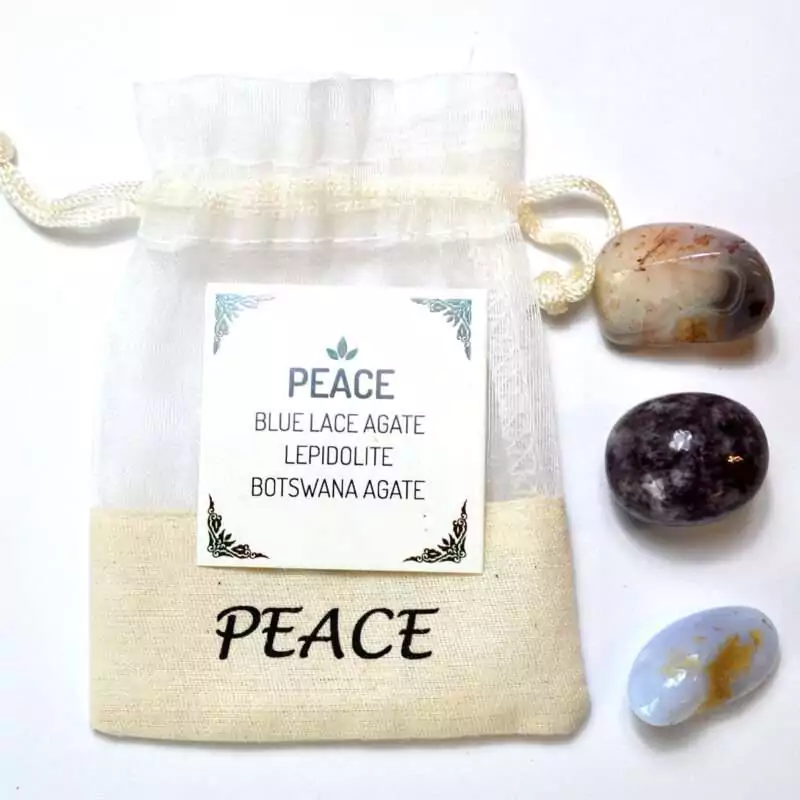 Peace-kit-GK1120 Peace Kit drawstring pouch labeled 'PEACE' with a card listing Blue Lace Agate, Lepidolite, and Botswana Agate, alongside the three polished tumbled stones displayed in front of the pouch.