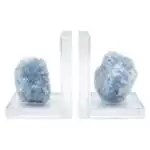 Matched pair of natural blue calcite slab bookends with soft sky-blue banding and translucent crystalline surface, shown propping books