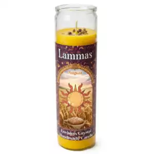Tall yellow Lammas aromatic jar candle by Envision Crystal, featuring a sun design and floral patterns on the label, encased in a clear glass holder — handmade sabbat candle for Lughnasadh ritual.