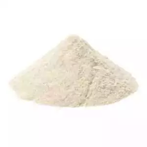 A small pile of pale cream-yellow gum arabic powder on a light surface, showing the fine ground texture of the acacia resin used for incense binding and ritual work.