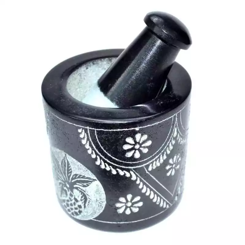 2-34quot-x-3quot-Flower-soapstone-mortar-pestle-set-LMS69 Black soapstone mortar and pestle set with a hand-carved floral vine engraving around the exterior of the bowl, pestle resting inside showing ground white powder residue.