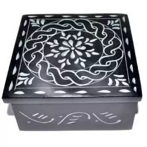 Black soapstone box with a hand-carved circular mandala design etched in pale lines across the lid, ringed by Celtic-style knotwork banding, approximately 4.25 inches square.
