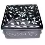 Black soapstone box with a hand-carved floral vine design etched in pale lines across the lid, surrounded by a leaf-and-petal border, approximately 4.25 inches square.