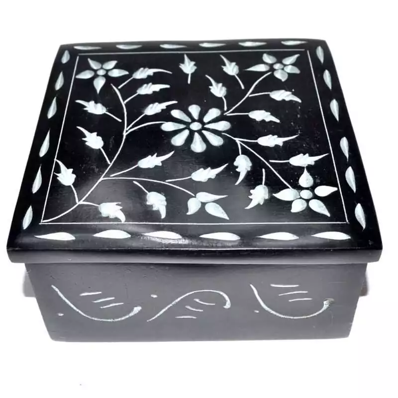 Black soapstone box with a hand-carved floral vine design etched in pale lines across the lid, surrounded by a leaf-and-petal border, approximately 4.25 inches square.