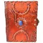 5 by 7 inch handcrafted leather journal with a woven triple moon design, a natural stone set at the center, and a side latch closure