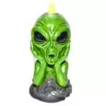 Painted green resin alien bust figurine with hands cupped against its face, seated on a gray sculpted cloud-like base, with a yellow backflow incense cone set atop its head.