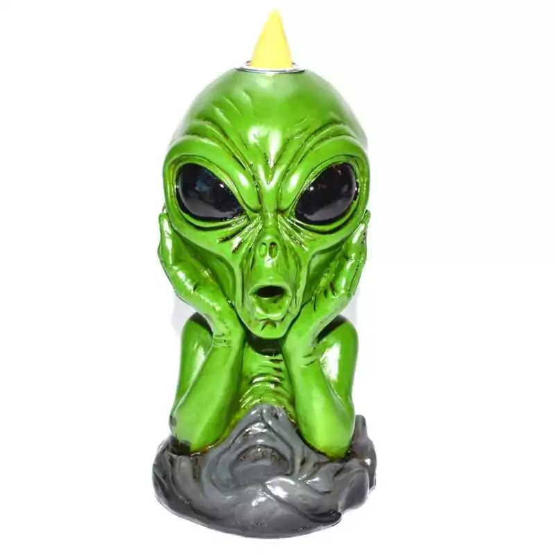 Painted green resin alien bust figurine with hands cupped against its face, seated on a gray sculpted cloud-like base, with a yellow backflow incense cone set atop its head.